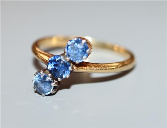 A three-stone light blue sapphire ring, 18ct yellow gold setting, size L.